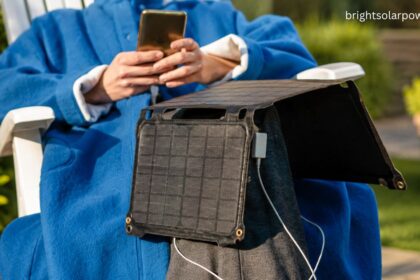 Solar mobile charger with portable foldable solar panel charging a smartphone outdoors.
